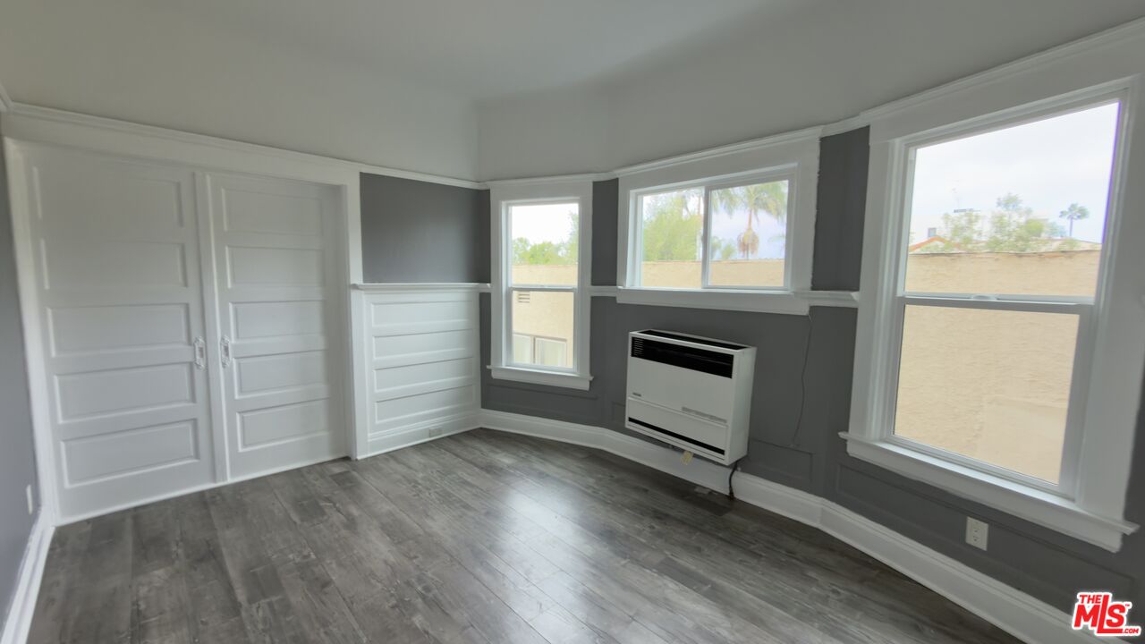1820 South Highland Avenue, Unit 1820 Los Angeles, CA 90019 - Photo 3 of 11 wooden floor in an empty room with a window