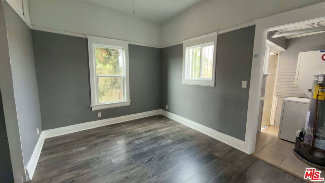 1820 South Highland Avenue, Unit 1820 Los Angeles, CA 90019 - Photo 6 of 11 an empty room with wooden floor and a window