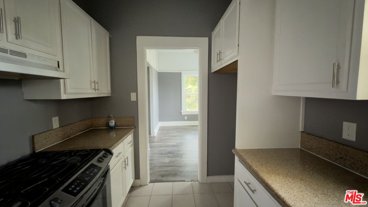 1820 South Highland Avenue, Unit 1820 Los Angeles, CA 90019 - Photo 7 of 11 a kitchen with stainless steel appliances granite countertop a stove and a refrigerator