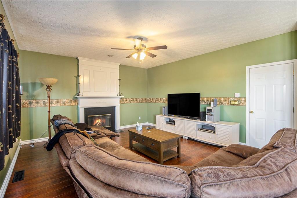 2054 Dartmoth Way Villa Rica, GA 30180 - Photo 4 of 45 a living room with furniture a fireplace and a flat screen tv