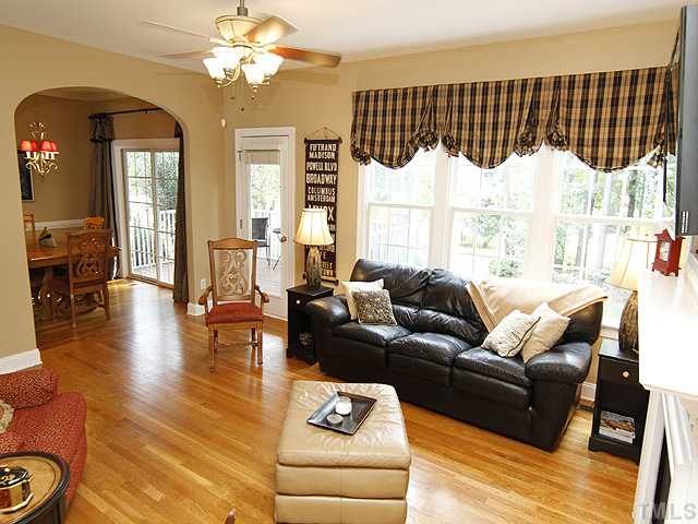Another view of living room showing how it opens to the dining room and to the screened porch.  There is plenty of light in this room, and the large windows look out on the beautiful back yard full of azaleas, Eastern red buds, dogwood trees, and peonies.
