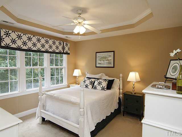 Tranquil master bedroom with trey ceiling and ceiling fan. Fresh, neutral paint.