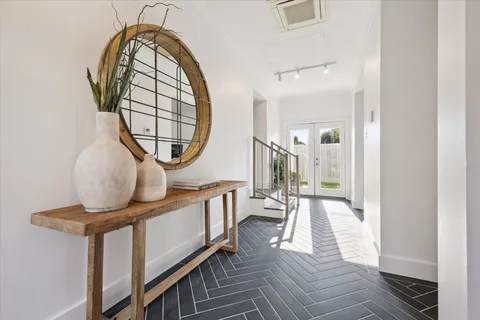 a living room with furniture a large window wooden floor and a rug