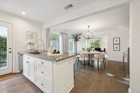 a view of a dining room and livingroom with furniture wooden floor a chandelier