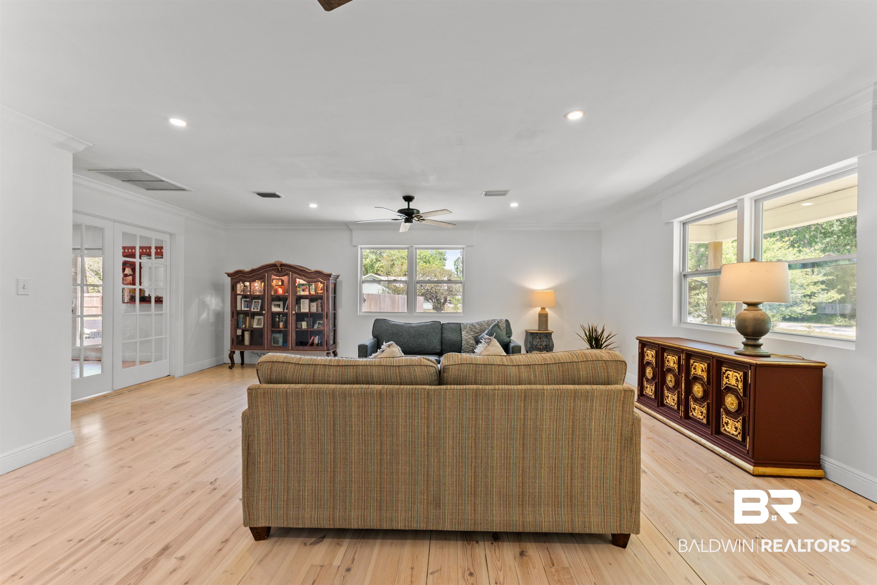 6447 Bemis Lane Bon Secour, AL 36511 - Photo 18 of 62 Expansive living area featuring light wood-finish flooring, white walls, and multiple windows