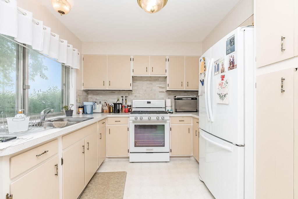 424 Devonshire Court Bolingbrook, IL 60440 - Photo 4 of 16 a kitchen with granite countertop white cabinets and white appliances