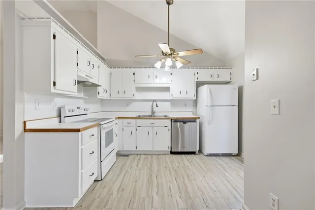 a kitchen with kitchen island white cabinets and white appliances