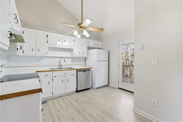 a kitchen with white cabinets and white appliances