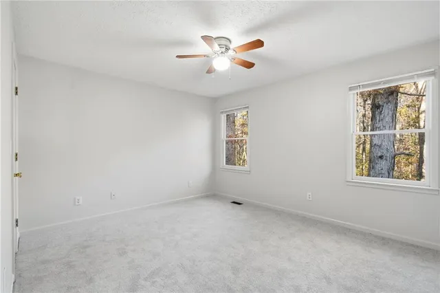 an empty room with a window and a ceiling fan