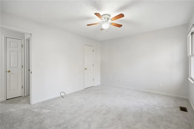 an empty room with a chandelier fan