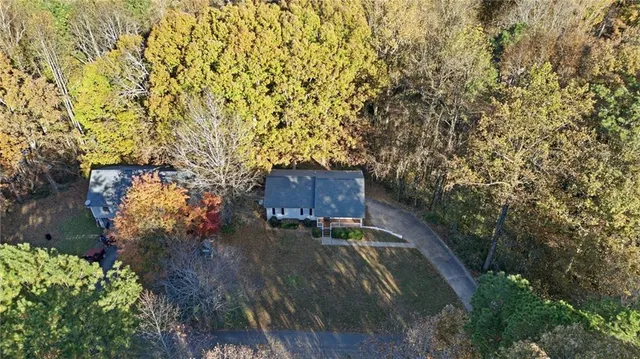 a view of a house with a yard and large trees