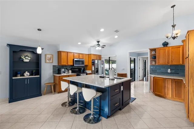 a kitchen with a dining table chairs and refrigerator