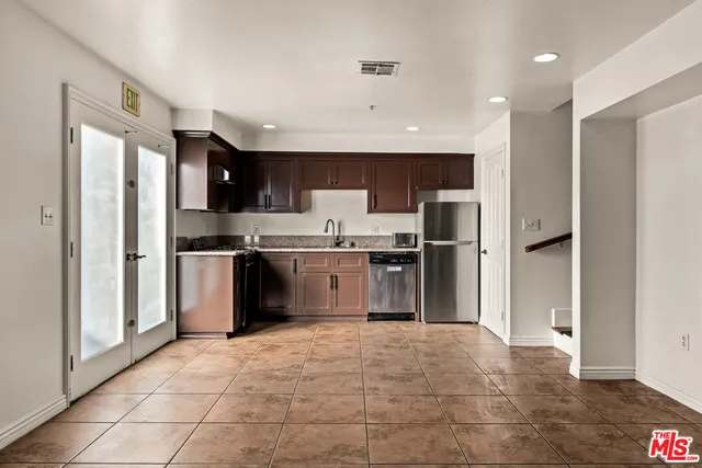 a kitchen with stainless steel appliances granite countertop a refrigerator and a sink