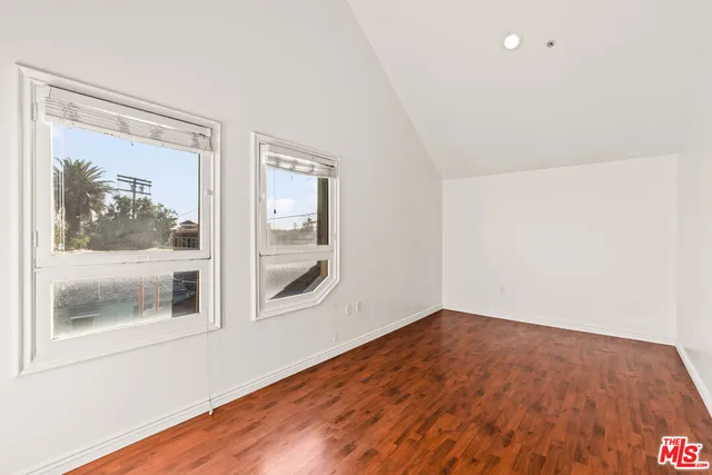 a view of empty room with wooden floor