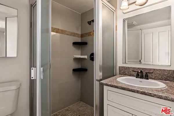 a bathroom with a granite countertop sink and a mirror