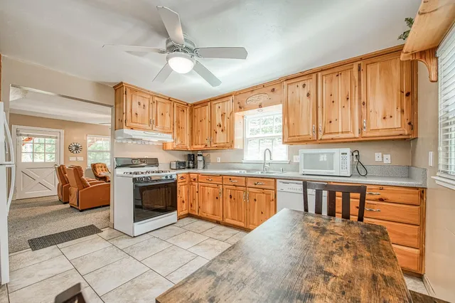 a large kitchen with stainless steel appliances granite countertop a stove refrigerator sink and cabinets