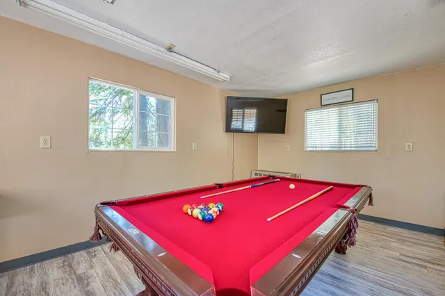 a room with pool table and windows