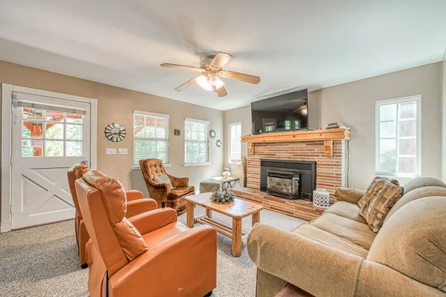a living room with furniture a fireplace and a large window