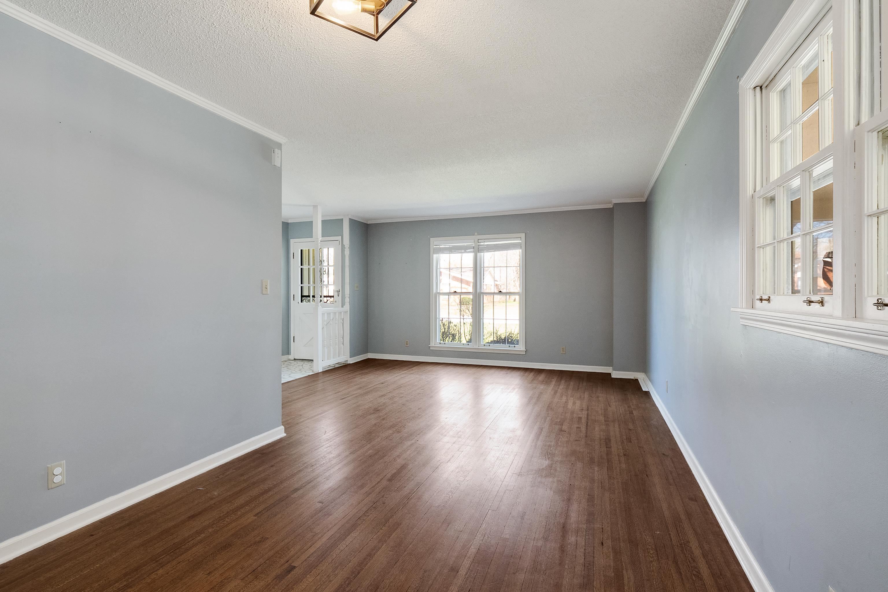 5849 Ridgevale Road Memphis, TN 38119 - Photo 5 of 22 an empty room with wooden floor and windows