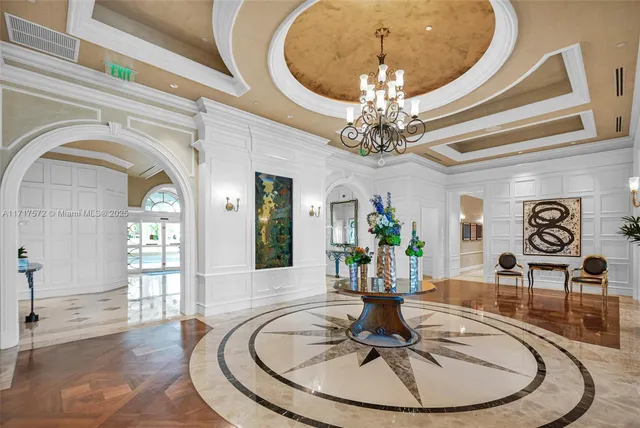 a dining room with wooden floor a chandelier a wooden table and chairs