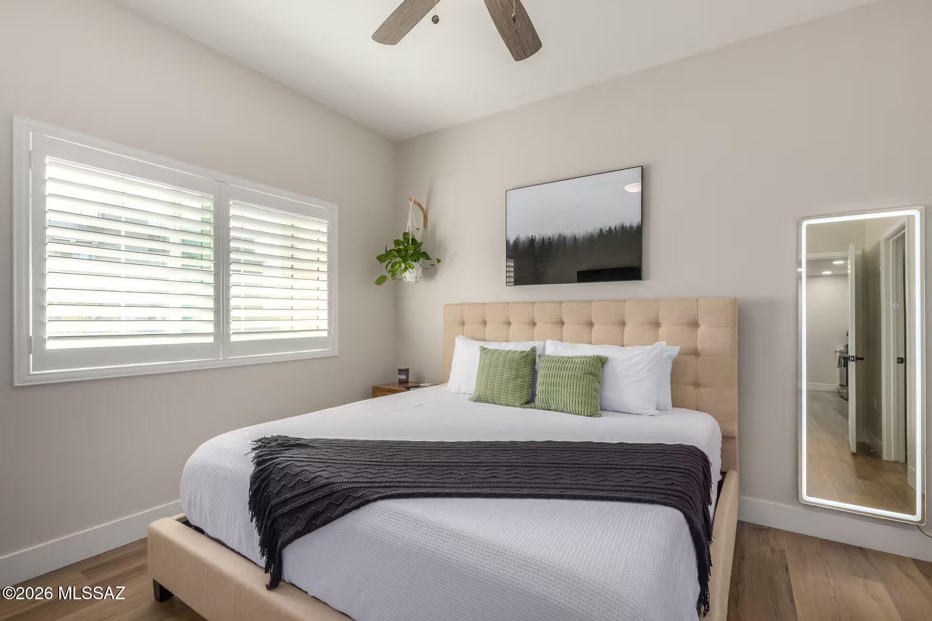 2036 East River Road, Unit 104 Tucson, AZ 85718 - Photo 9 of 23 a bedroom with a large bed and a flat screen tv