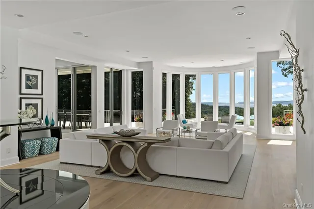 a dining room with furniture and large windows