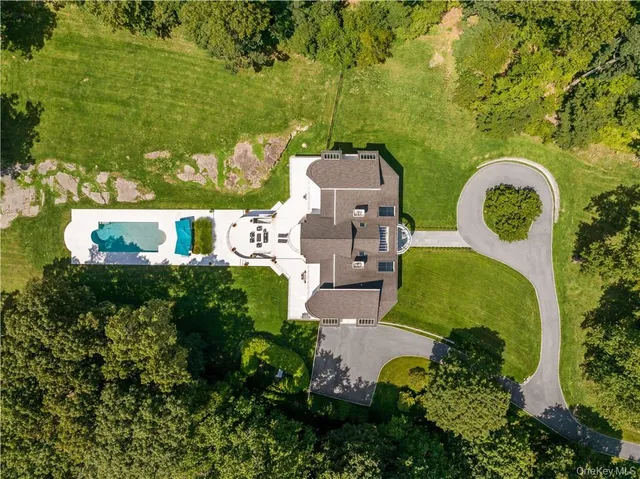 an aerial view of a house with a garden and lake view