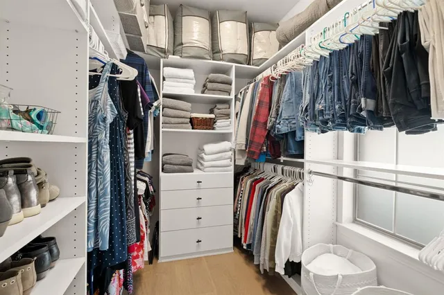 a view of walk in closet with clothes and shoes