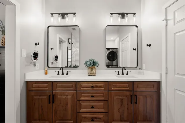 a bathroom with double vanity sinks and a mirror