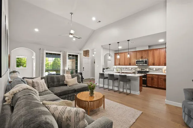 a living room with furniture kitchen and a large window