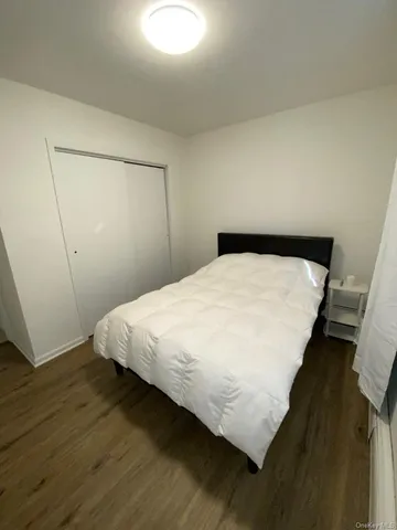 a bed sitting in a bedroom next to a cabinet