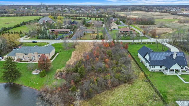 an aerial view of a house with a garden and lake view
