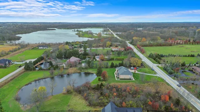 an aerial view of a house with a garden and lake view