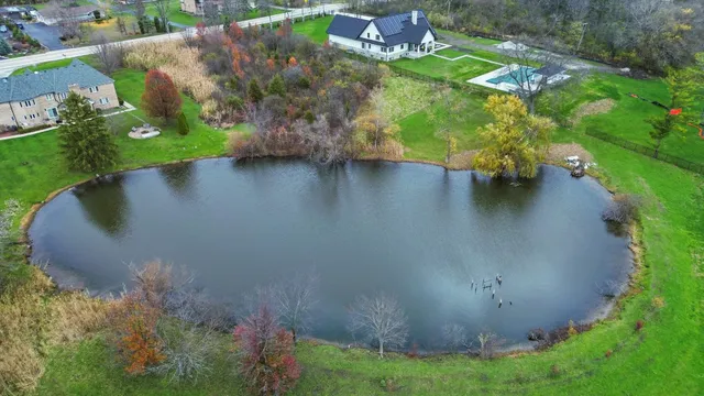 an aerial view of a house with a yard and lake view
