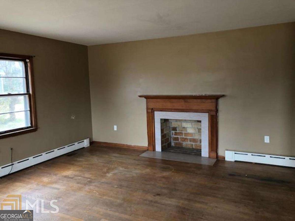 329 McDonough Road Jackson, GA 30233 - Photo 4 of 11 an empty room with a fireplace