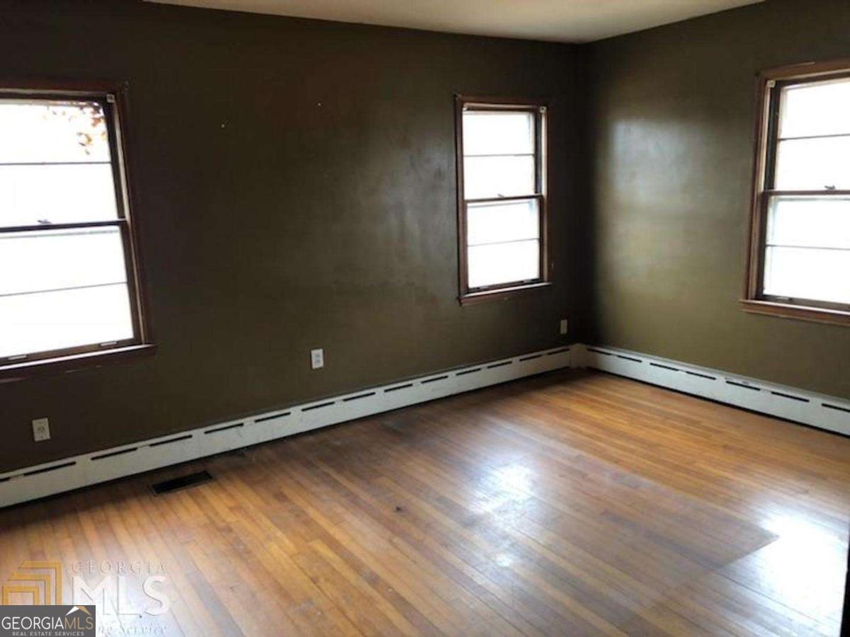 329 McDonough Road Jackson, GA 30233 - Photo 7 of 11 an empty room with wooden floor and windows