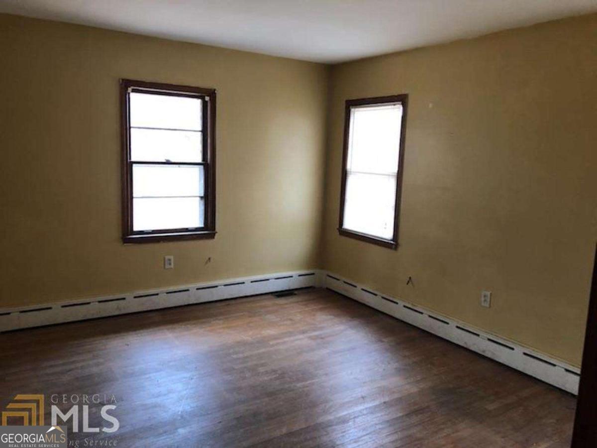 329 McDonough Road Jackson, GA 30233 - Photo 9 of 11 an empty room with wooden floor and windows
