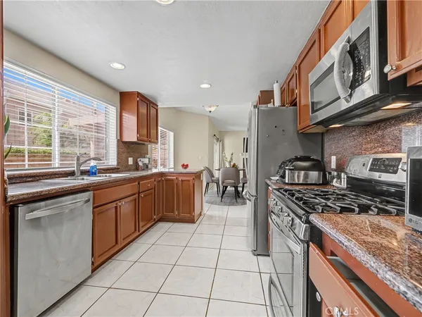 a kitchen with stainless steel appliances granite countertop a stove a sink and a microwave