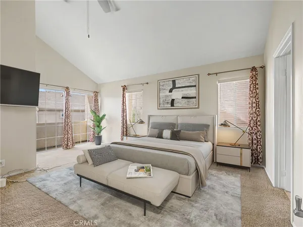 a bedroom with a bed a couch and a flat screen tv