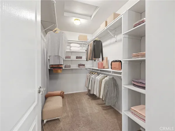 a view of walk in closet with clothes and shoes