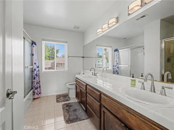 a spacious bathroom with a granite countertop sink a mirror and a shower