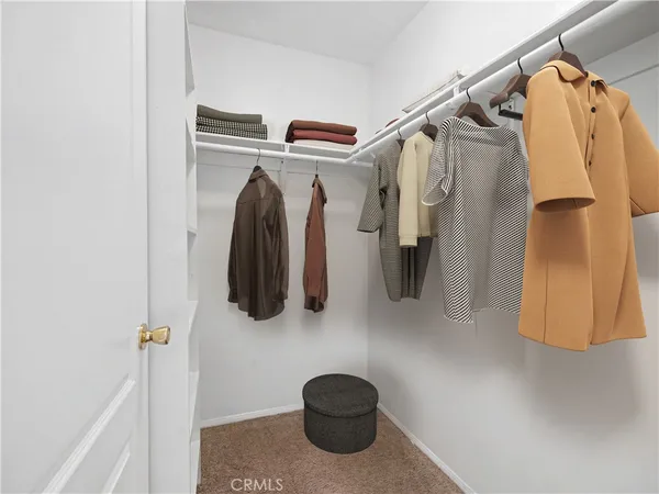 a view of walk in closet with clothes and shoes