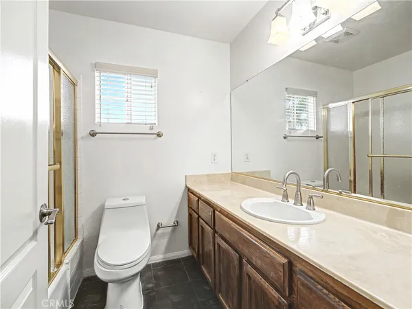 a bathroom with a sink a toilet a mirror and a shower