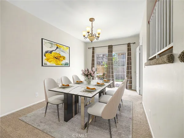 a view of a dining room with furniture a chandelier and wooden floor