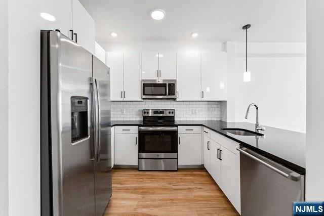 520 Cliff Street, Unit 503 Fairview, NJ 07022 - Photo 7 of 22 a kitchen with stainless steel appliances granite countertop a refrigerator a stove a sink and a microwave