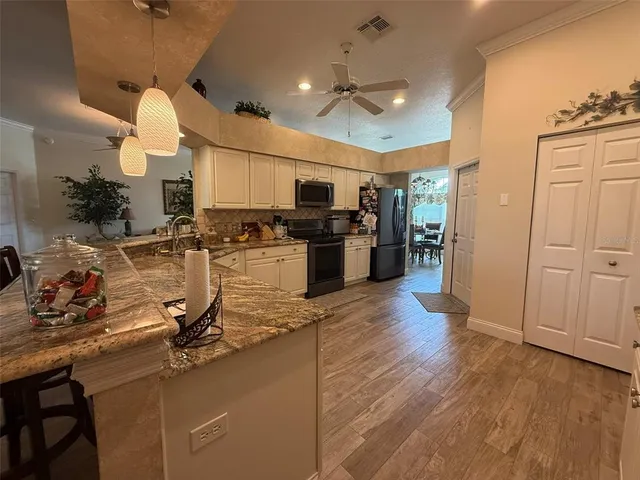 a view of a kitchen with refrigerator microwave and stove top oven