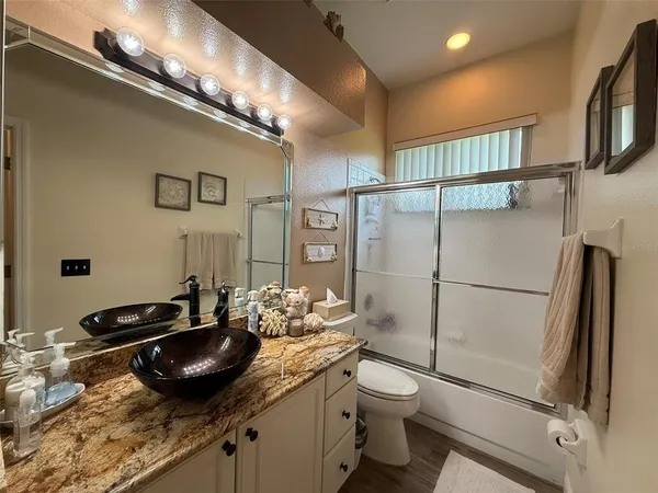 a bathroom with a granite countertop sink a toilet and a mirror