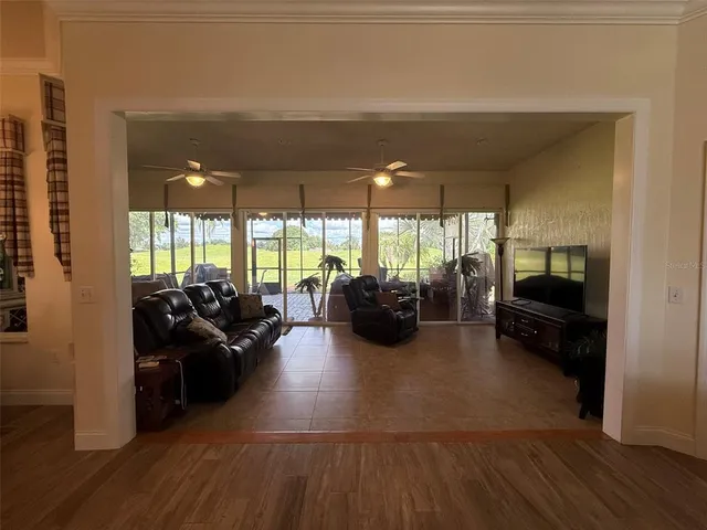 a living room with furniture floor to ceiling window and a flat screen tv