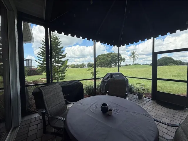 a view of a porch with furniture and a yard