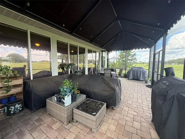 a living room with patio furniture and a potted plant